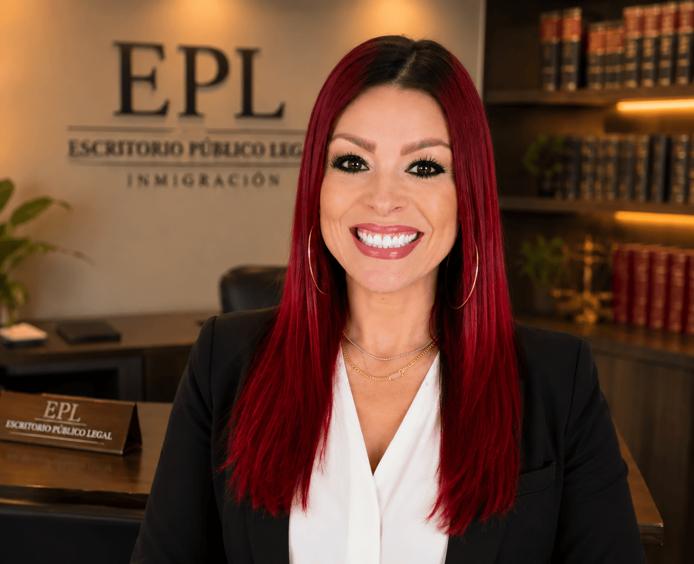 Mujer de cabello rojo sonriendo en una oficina legal con el logotipo de EPL.